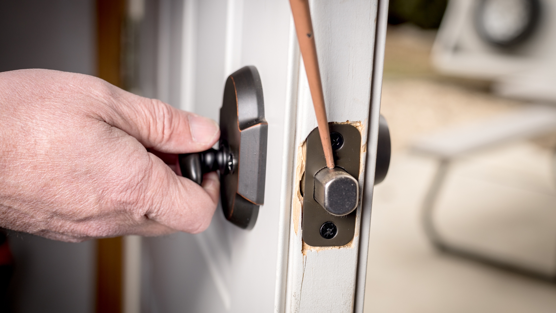 A locksmith applying doo lock lubricants to a lock latch