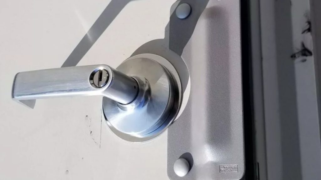 A latch guard on a metal commercial door