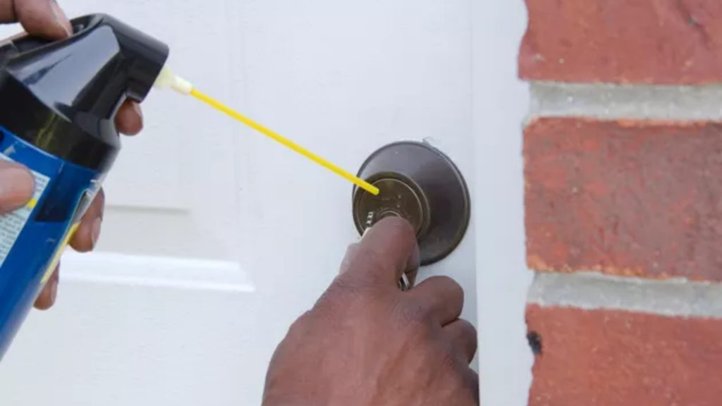 A technician lubricating a commercial lock
