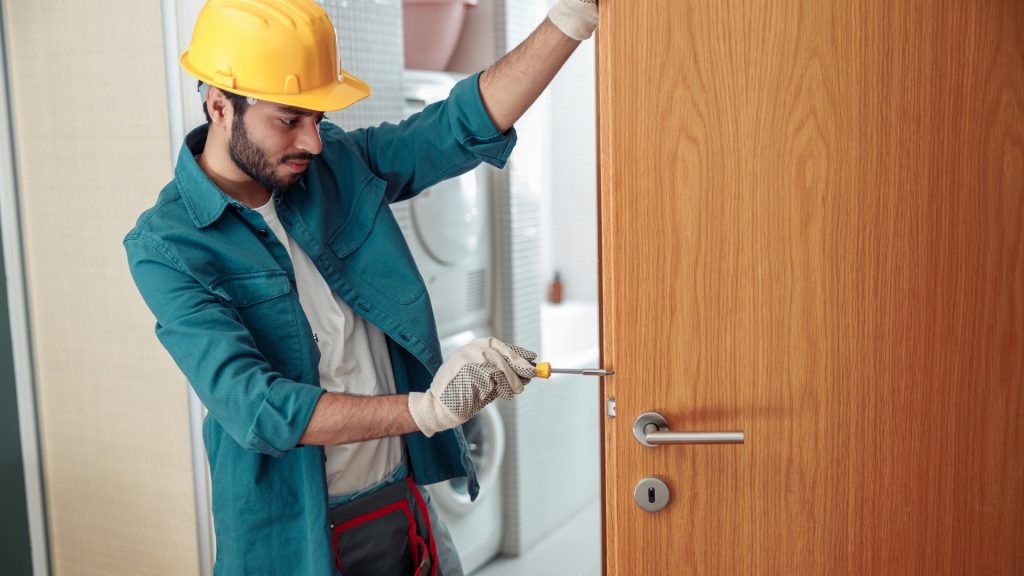 A residential locksmith installing a lever lock on a door