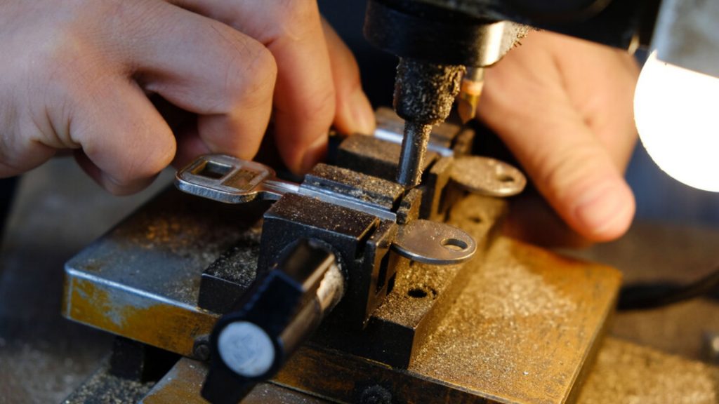 A locksmith performing key duplication on a machine