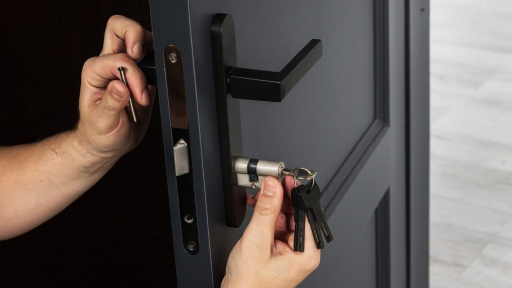 Locksmith services technician rekeying a front door lock for home security