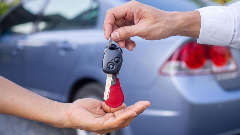 A car owner in South Pasadena receiving a car key fob from a certified locksmith beside a vehicle