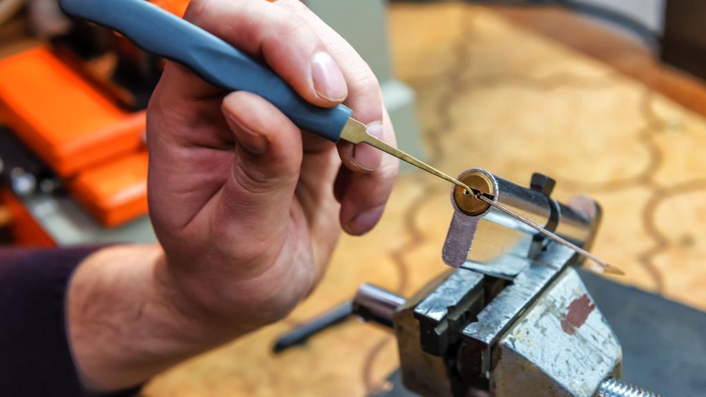 Rekeying a residential door lock cylinder using locksmith tools on a workbench