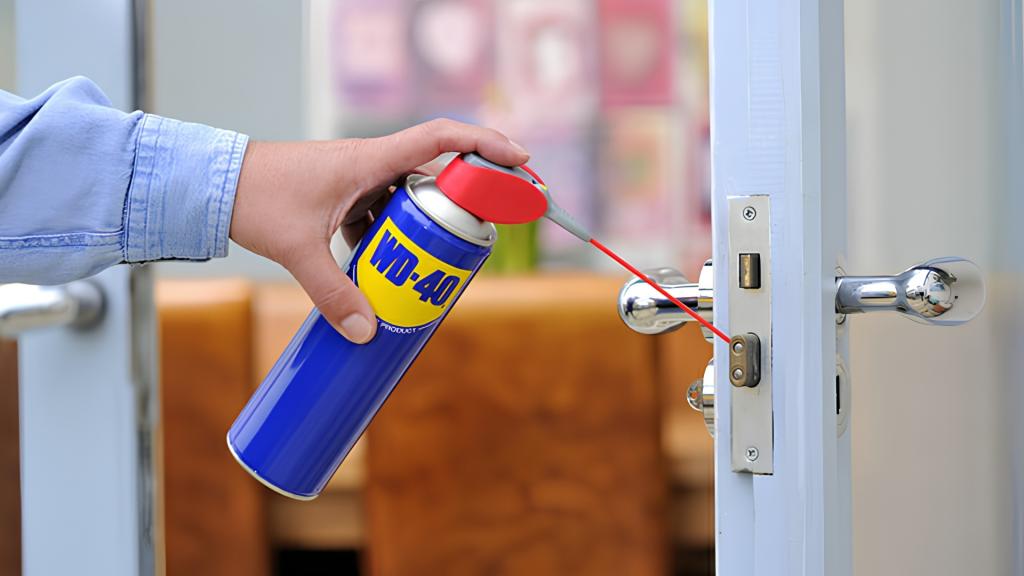 Hand applying lubricant to a commercial door lock to help fix a storefront lock jammed issue and restore smooth operation